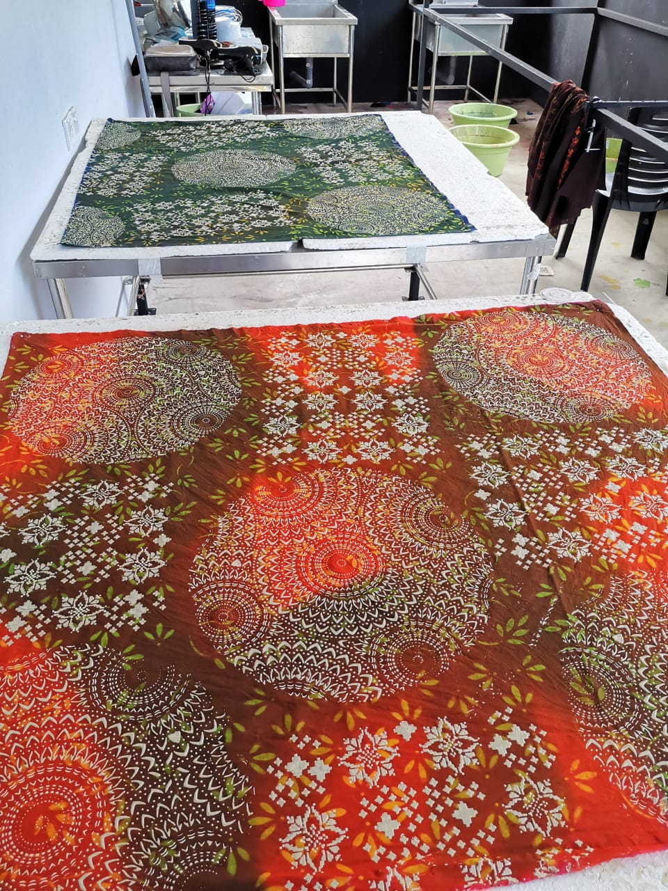 Hasil kain Batik Tanah Liat dalam tona merah dan hijau